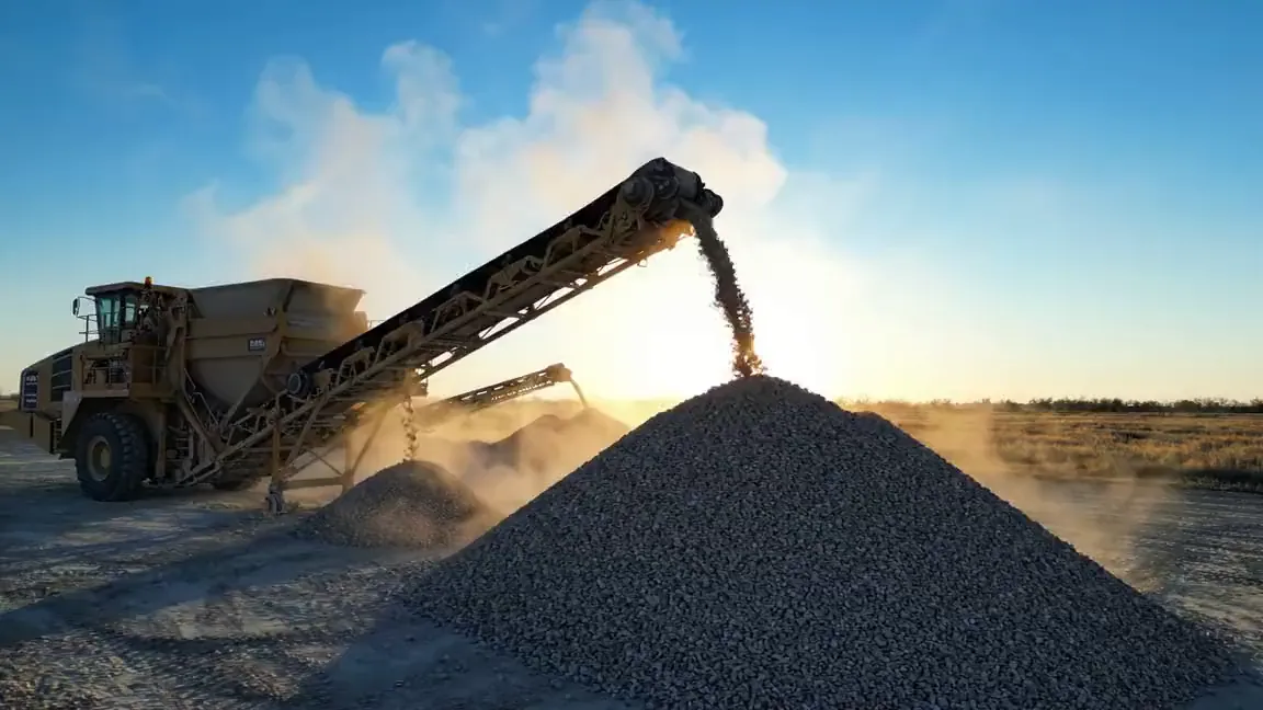 Conveyor building an aggregate stockpile beside a portable plant