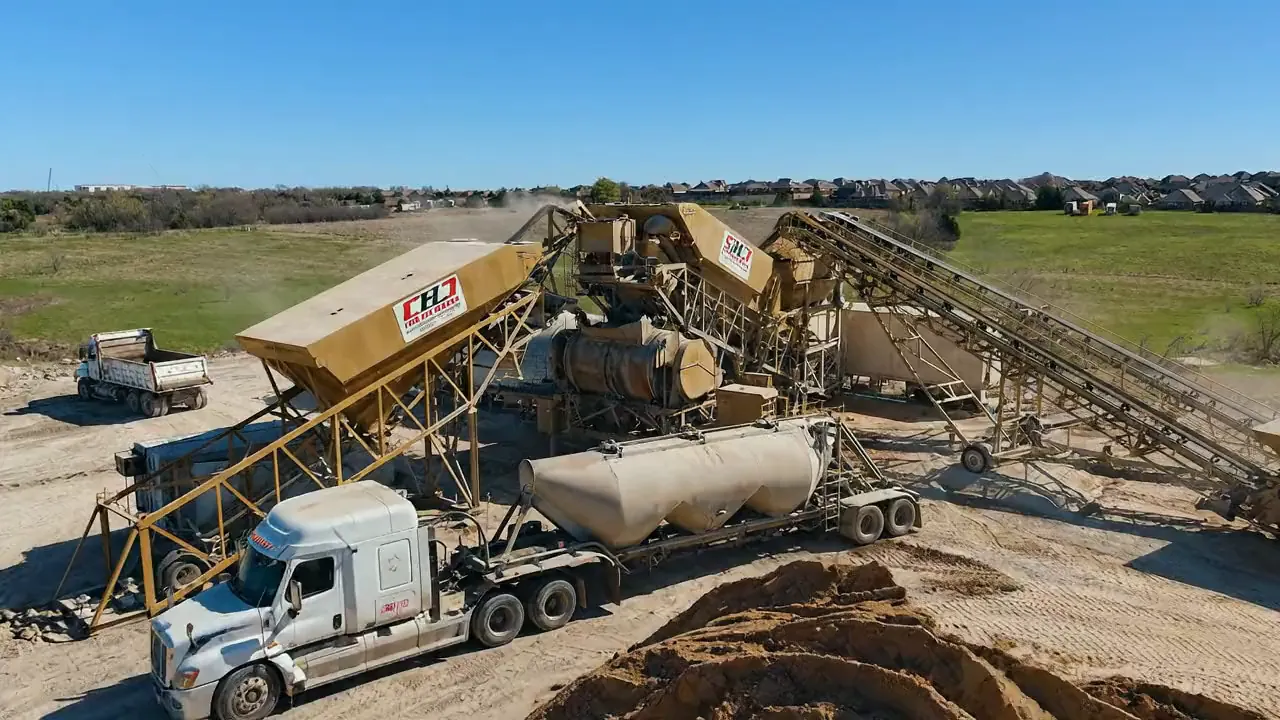 Aerial view of a Chris Harp Construction plant with haul trucks and a ready-mix unit loading