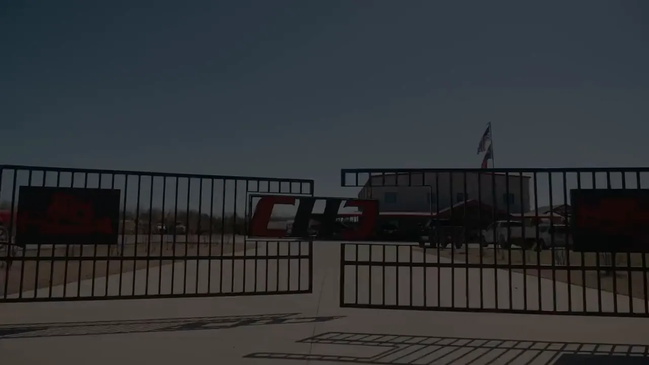 The Chris Harp Construction yard gate with the company mark on it, opening the brand film